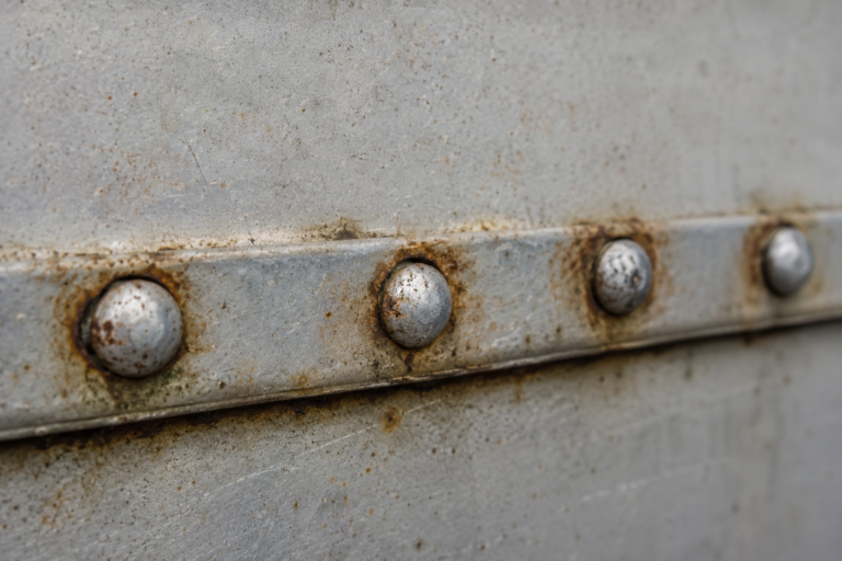 Corrosion and staining around blind rivets installed in weathered sheet metal